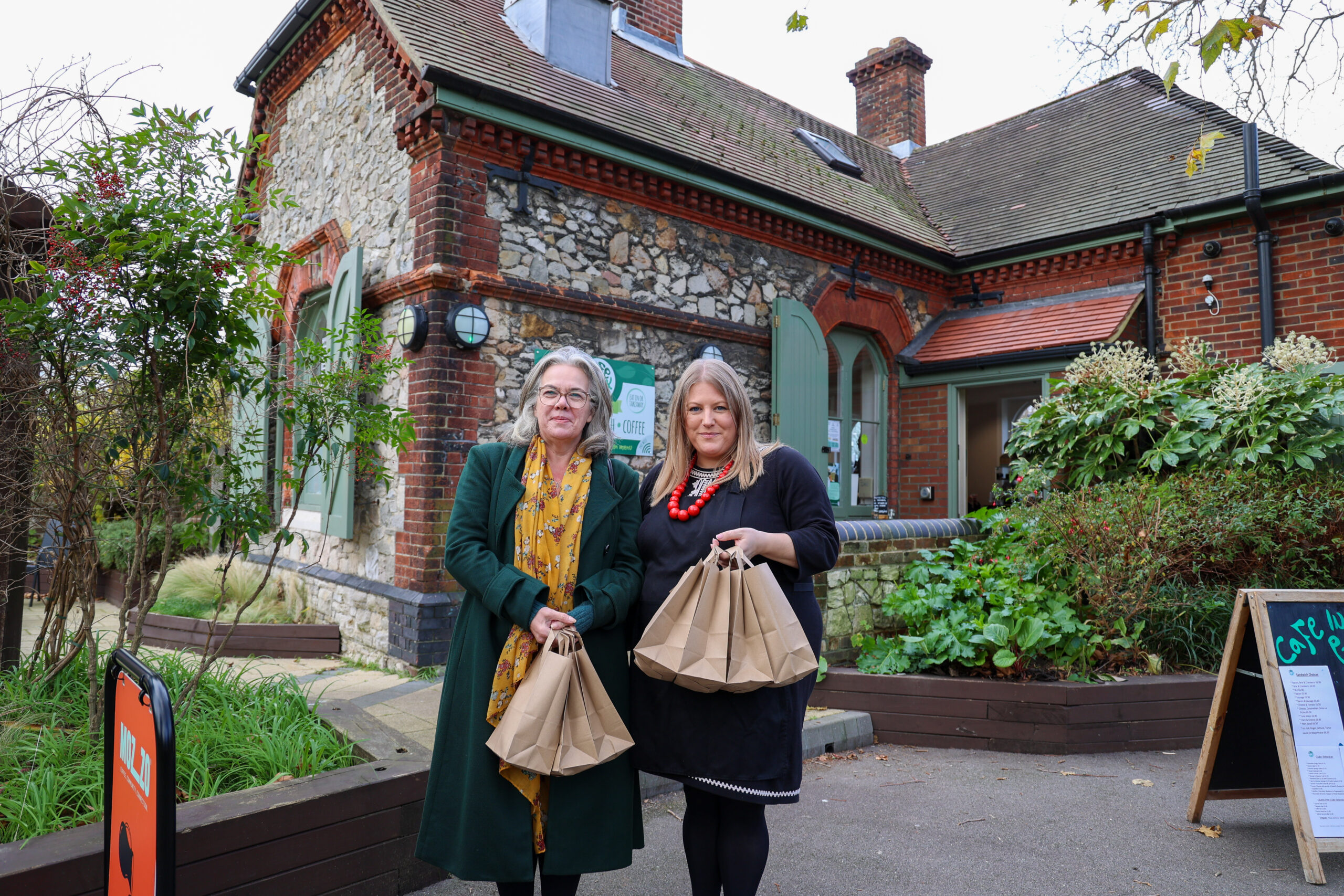 SSJ CEO Tania Marsh and PCC Donna Jones holding festive food bags outside Cafe in the Park